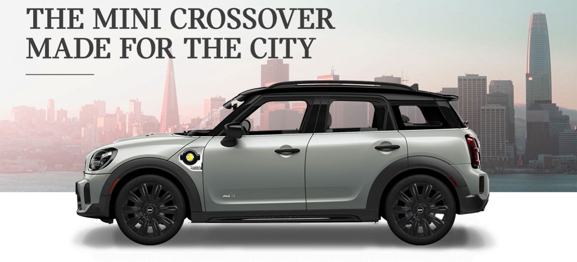 The MINI Cooper SE Countryman PHEV parked in front of a city scape. MINI of Pittsburgh in Pittsburgh PA