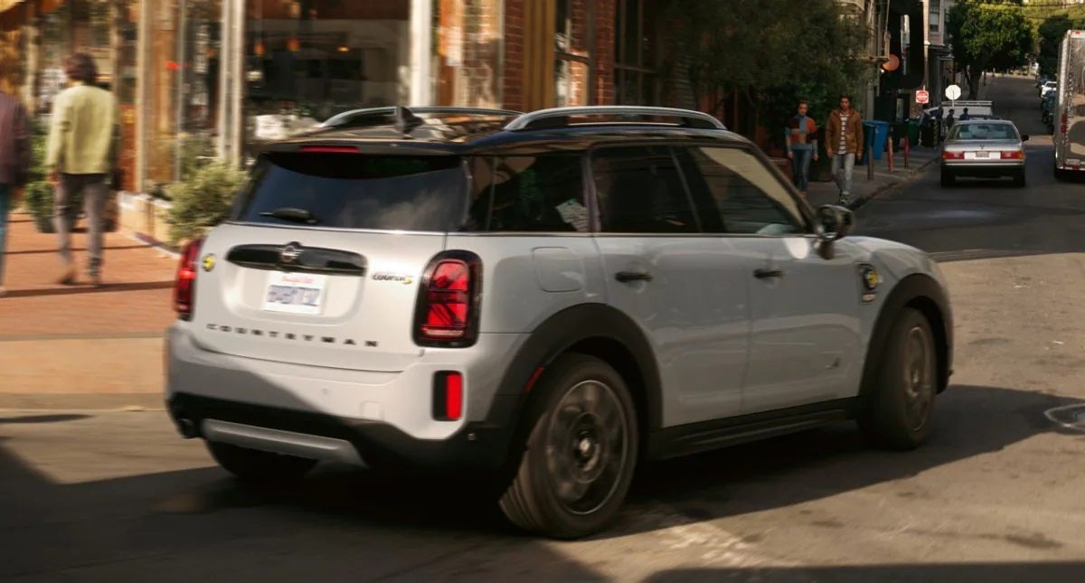 The MINI Cooper SE Countryman PHEV turning a corner in the city. MINI of Pittsburgh in Pittsburgh PA