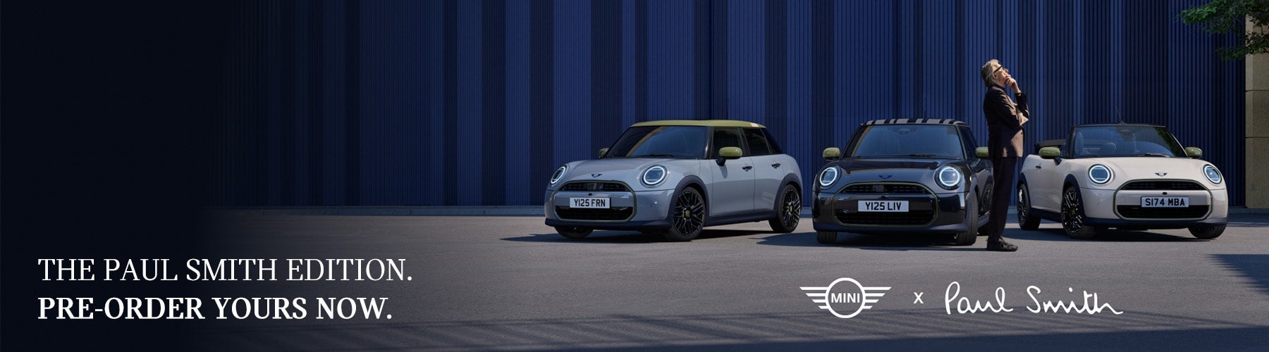 Three Mini Cooper cars, light gray, black, and white, with a person standing next to the black car.